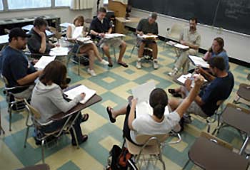 Interior, High-Angle photo of a Professor having a Discussion with his Students inside a Classroom