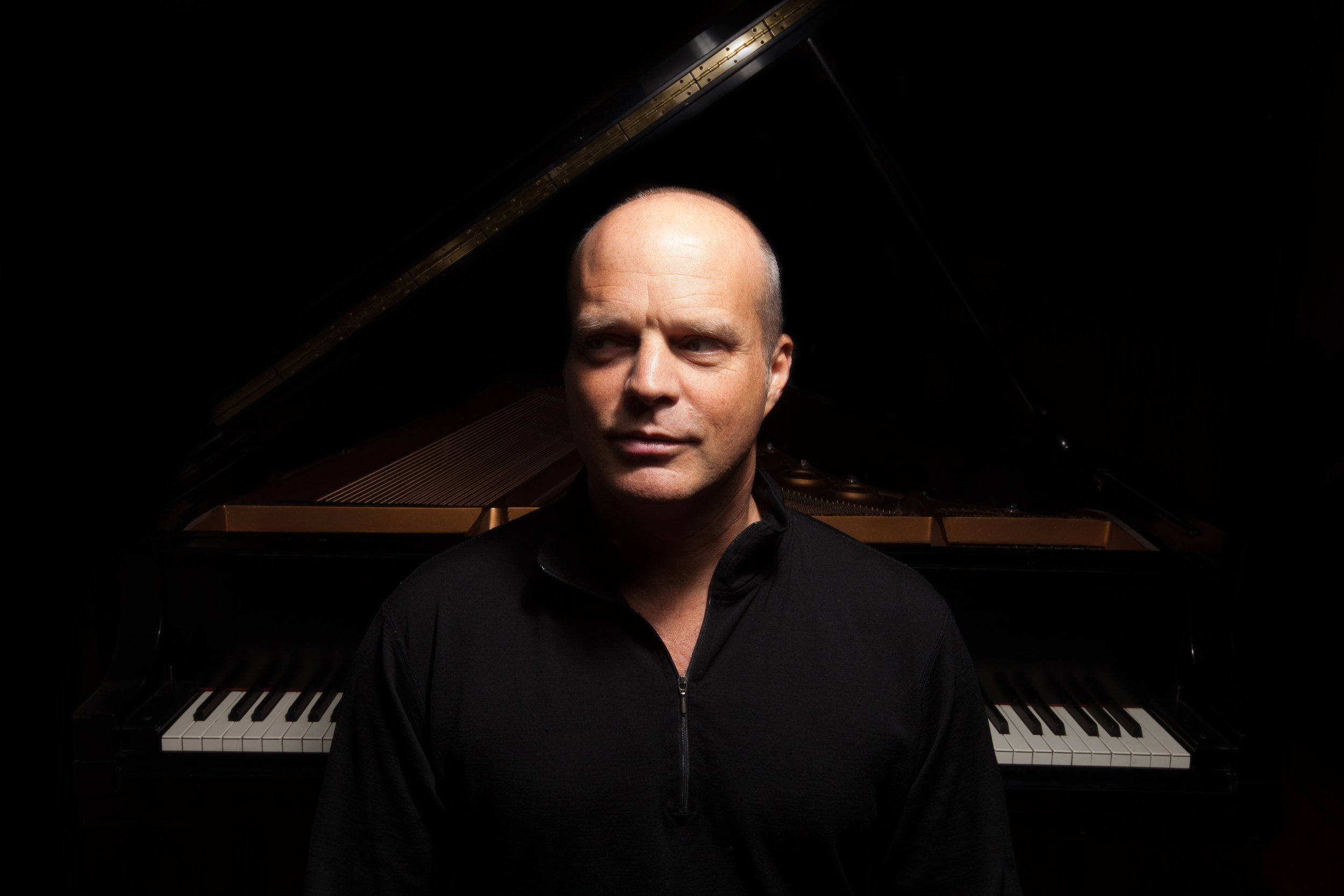 Photo of John Medeski in front of his piano (almost like a silhouette)